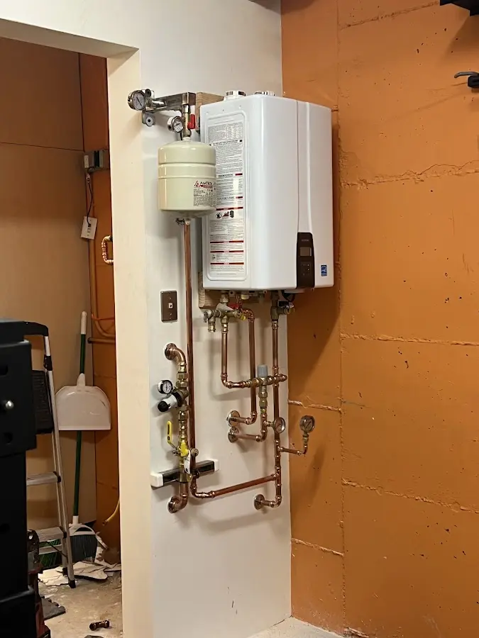 Plumbing technician inspecting water heater connections in Berea